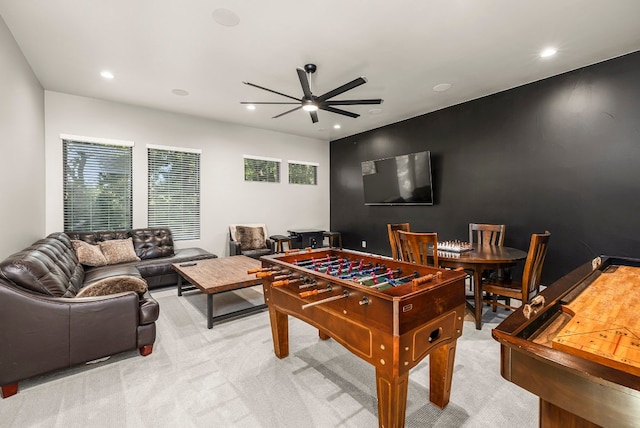 recreation room with ceiling fan and light carpet