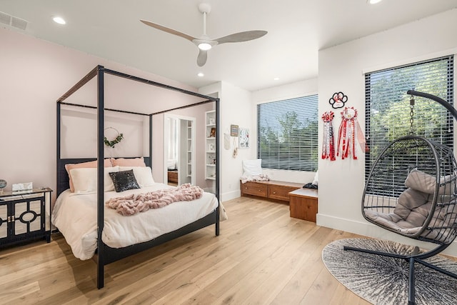 bedroom with multiple windows, ceiling fan, and light hardwood / wood-style flooring