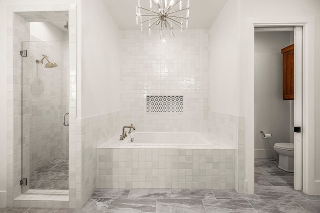 bathroom featuring plus walk in shower, an inviting chandelier, and toilet