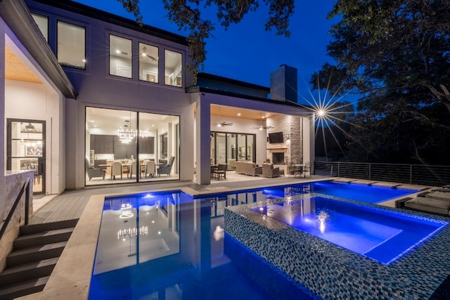 view of swimming pool featuring an outdoor living space with a fireplace, an in ground hot tub, ceiling fan, and a patio