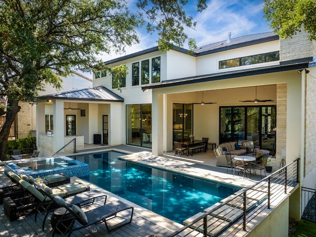 back of property featuring a patio area, ceiling fan, and a pool with hot tub