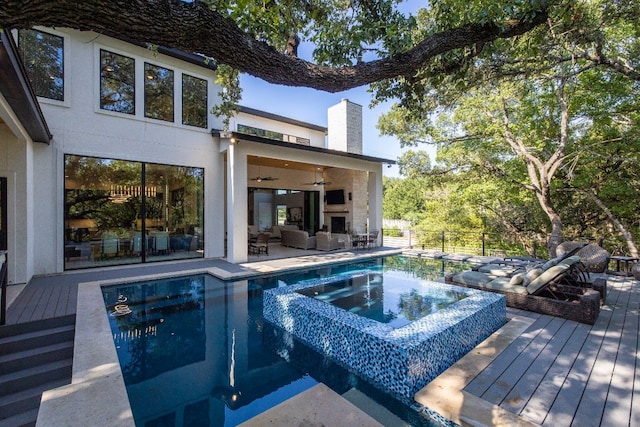 view of pool with an in ground hot tub, an outdoor hangout area, a deck, and ceiling fan