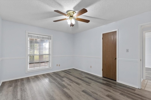 empty room featuring ceiling fan, a textured ceiling, and hardwood / wood-style flooring