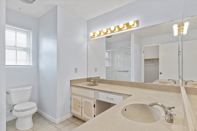 bathroom with walk in shower, vanity, a textured ceiling, tile patterned flooring, and toilet