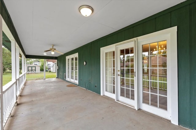 unfurnished sunroom with ceiling fan with notable chandelier