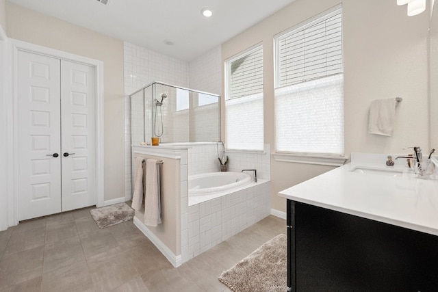 bathroom with plus walk in shower, plenty of natural light, and vanity