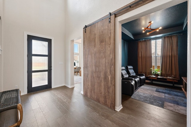 foyer featuring hardwood / wood-style flooring, a barn door, and a chandelier