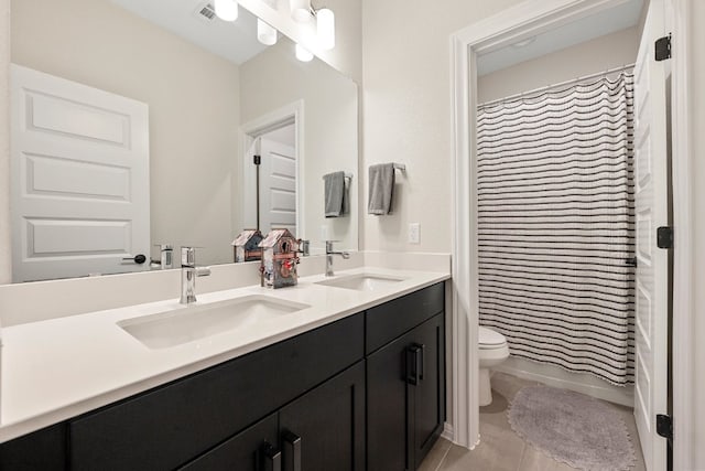 full bathroom featuring tile patterned floors, vanity, toilet, and shower / bath combo with shower curtain