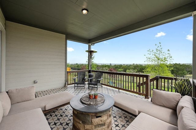 exterior space featuring a wooden deck and an outdoor living space with a fire pit