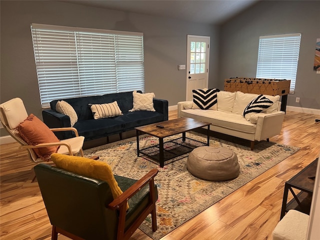 living room with vaulted ceiling and light wood-type flooring