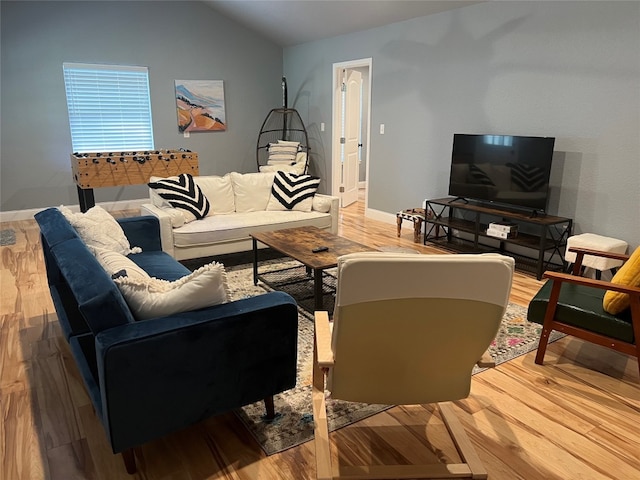 living room featuring vaulted ceiling and light hardwood / wood-style floors