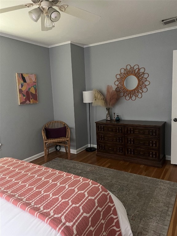 bedroom featuring dark wood-type flooring, ornamental molding, and ceiling fan