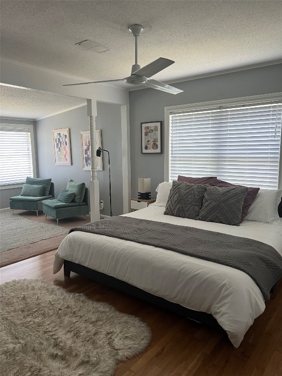 bedroom featuring a textured ceiling, dark hardwood / wood-style floors, and ceiling fan