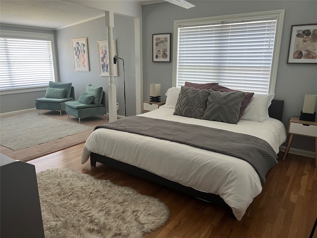 bedroom featuring a textured ceiling, wood-type flooring, and ornamental molding