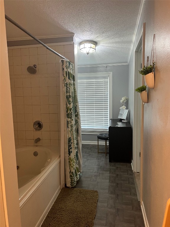 bathroom with a textured ceiling, crown molding, and shower / bath combo with shower curtain