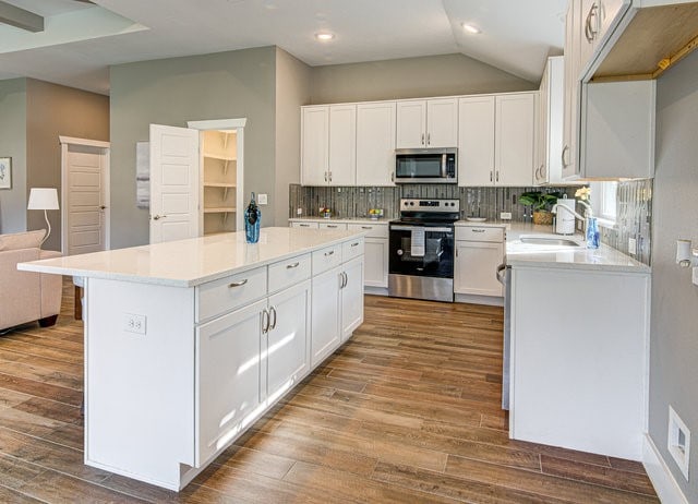 kitchen featuring white cabinets, appliances with stainless steel finishes, light hardwood / wood-style flooring, and sink