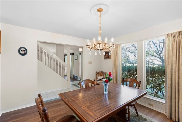 dining space featuring a healthy amount of sunlight, hardwood / wood-style flooring, and a chandelier