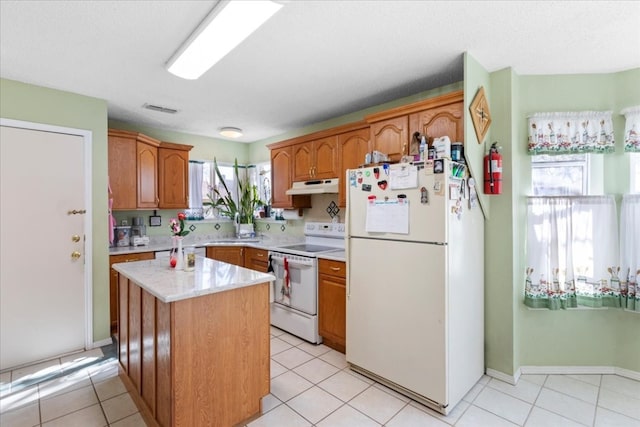 kitchen featuring white appliances, a wealth of natural light, and light tile flooring