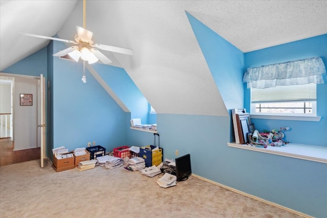 playroom with a textured ceiling, carpet, ceiling fan, and vaulted ceiling