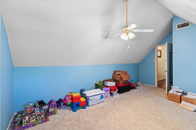 game room featuring a textured ceiling, carpet flooring, ceiling fan, and vaulted ceiling