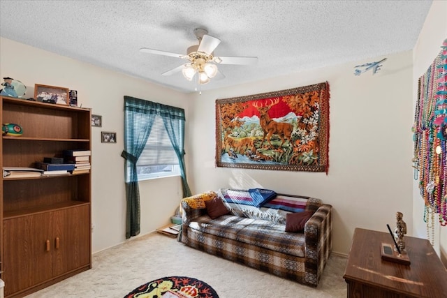 living room with ceiling fan, a textured ceiling, and carpet floors