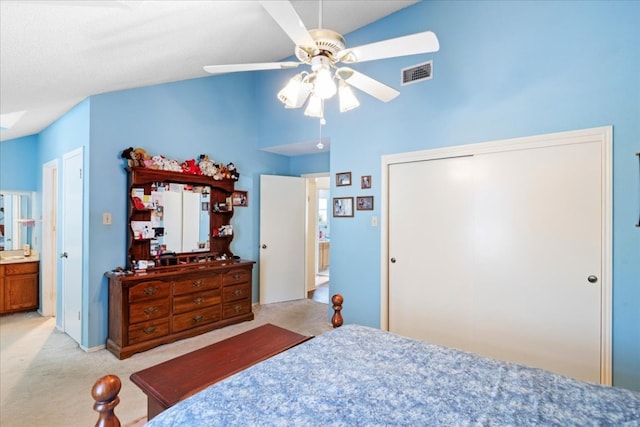 bedroom with light carpet, high vaulted ceiling, ensuite bathroom, and ceiling fan