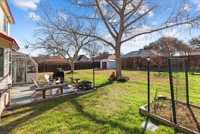 view of yard featuring a shed, a fire pit, and a patio