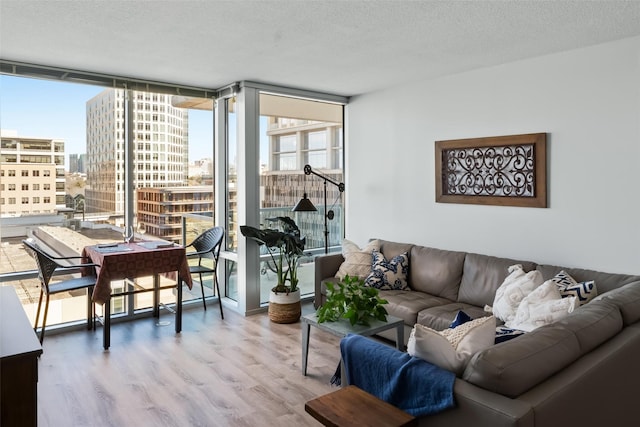 living room featuring wood-type flooring, expansive windows, and a textured ceiling