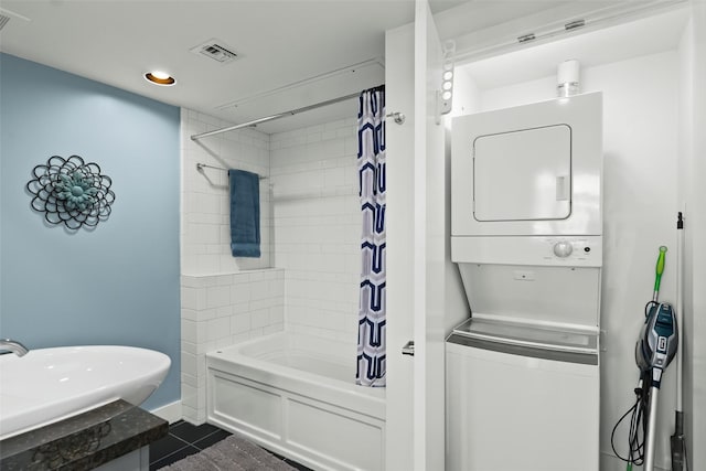 bathroom with tile patterned flooring, vanity, stacked washer and dryer, and shower / tub combo with curtain