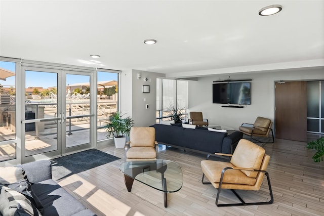 living room featuring french doors, floor to ceiling windows, and light hardwood / wood-style floors