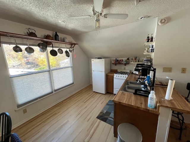 office area featuring vaulted ceiling, ceiling fan, a textured ceiling, light hardwood / wood-style flooring, and sink