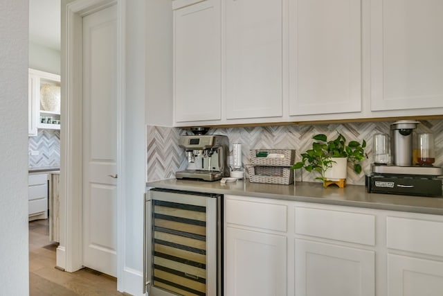 bar with a bar, light wood finished floors, wine cooler, and decorative backsplash