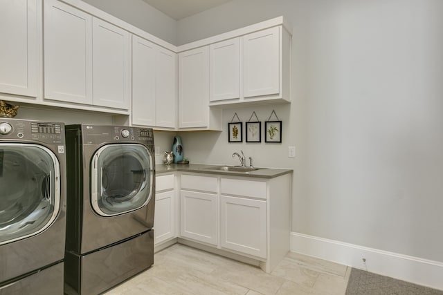 washroom with sink, cabinets, and washing machine and dryer