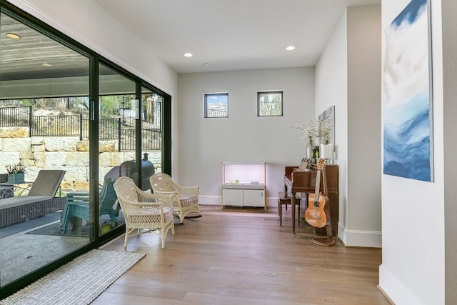 living area featuring recessed lighting, wood finished floors, and baseboards