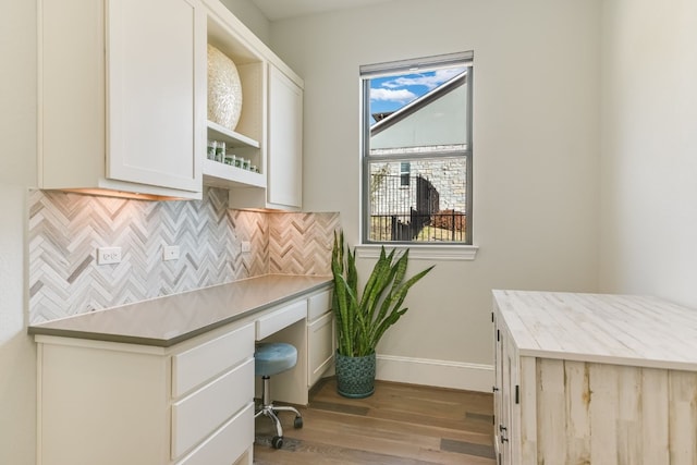 home office featuring light wood-style floors, built in study area, and baseboards