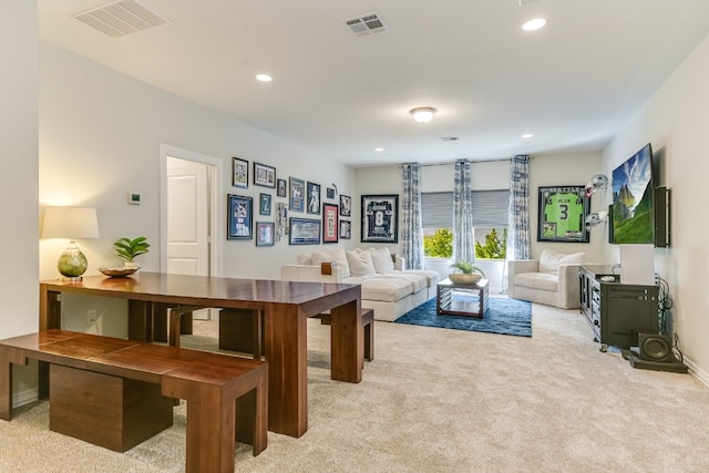 living room with recessed lighting, light colored carpet, and visible vents