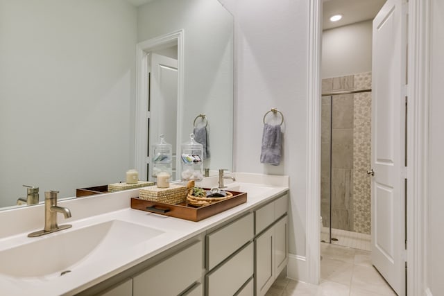 bathroom with vanity, tile patterned flooring, and tiled shower