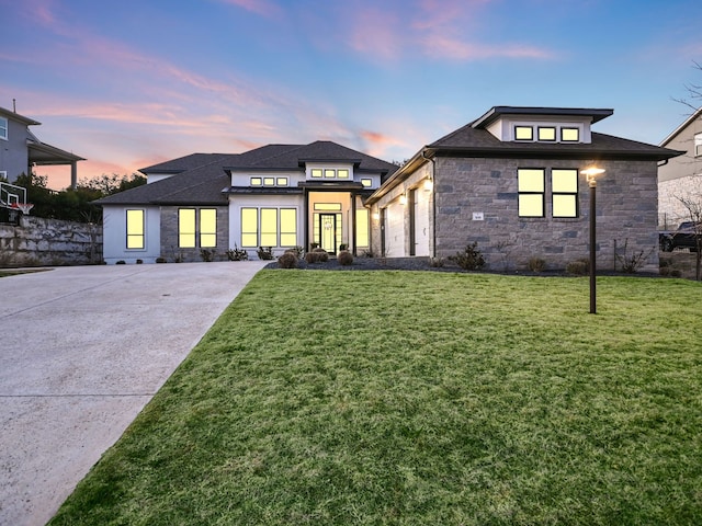 prairie-style house featuring a lawn and a garage