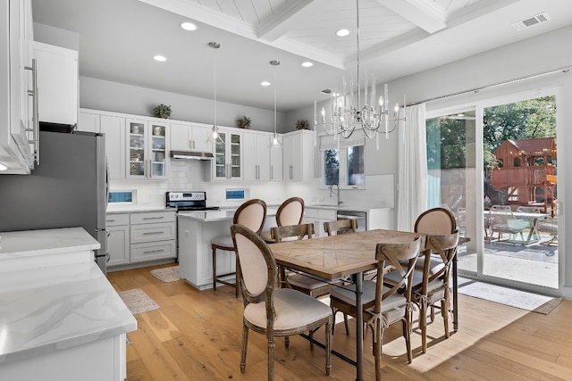 dining space featuring light wood finished floors, visible vents, coffered ceiling, beamed ceiling, and a chandelier