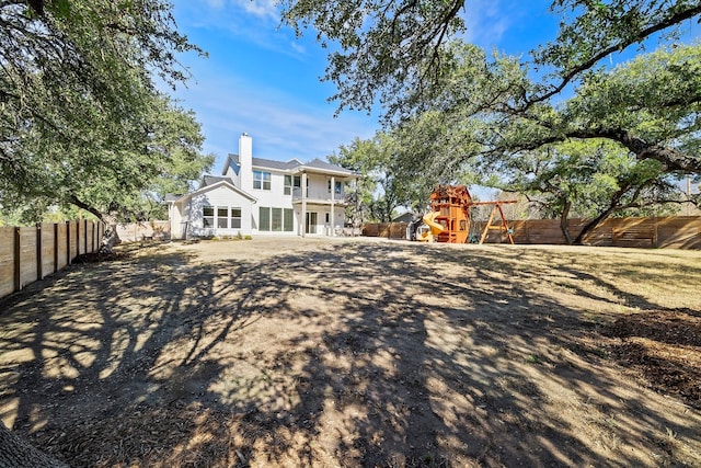 back of property with a playground