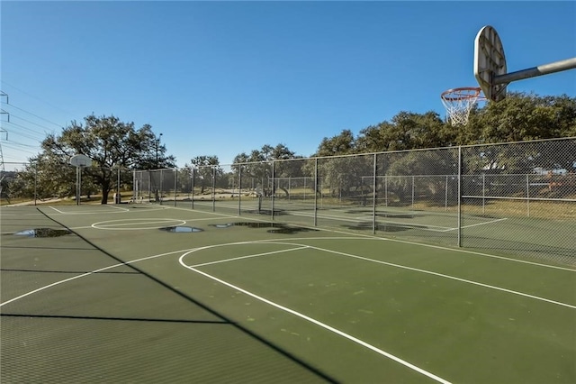 view of sport court featuring a tennis court, community basketball court, and fence