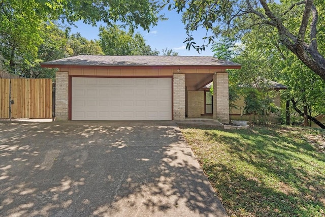 ranch-style house with concrete driveway, an attached garage, fence, a front yard, and brick siding