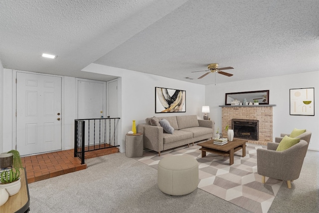 carpeted living room featuring a textured ceiling, a fireplace, and ceiling fan