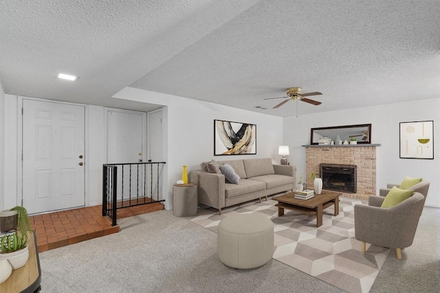 carpeted living area featuring a fireplace, a textured ceiling, and ceiling fan