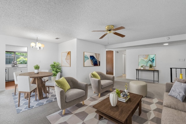 carpeted living room featuring a textured ceiling and ceiling fan with notable chandelier