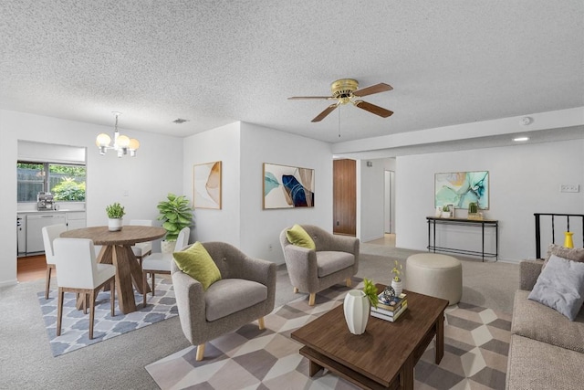 living room featuring ceiling fan with notable chandelier, light carpet, visible vents, and a textured ceiling
