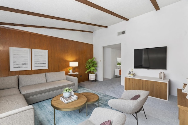 living room featuring wooden walls, vaulted ceiling with beams, a textured ceiling, and light carpet