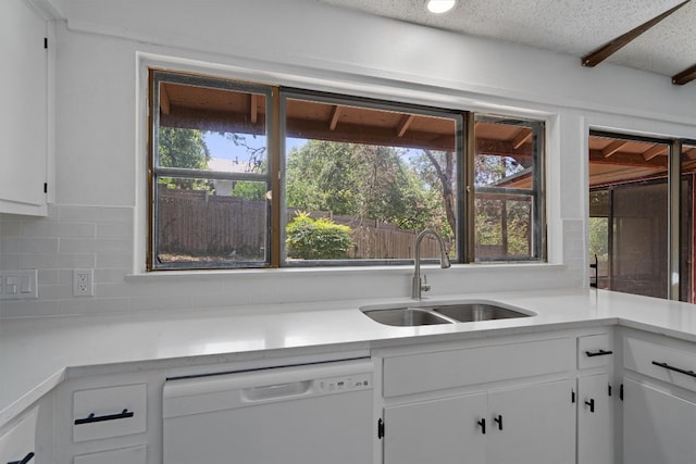 kitchen with dishwasher, sink, white cabinets, decorative backsplash, and a healthy amount of sunlight