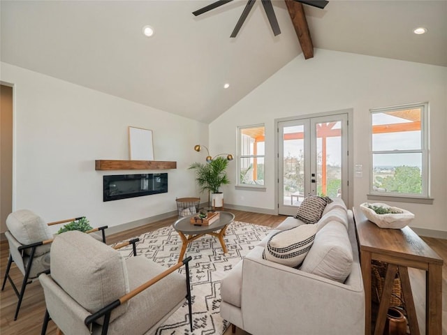 living room with french doors, light wood-type flooring, beamed ceiling, ceiling fan, and high vaulted ceiling