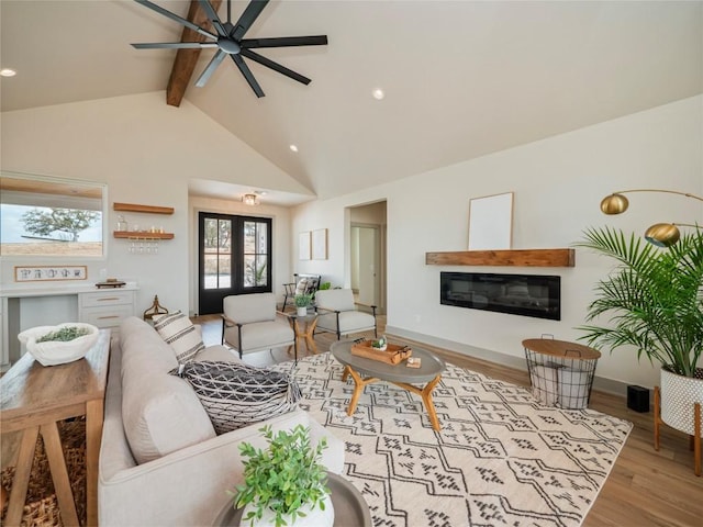 living room with light wood-type flooring, french doors, beam ceiling, ceiling fan, and high vaulted ceiling